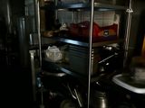 a kitchen with many pots and pans on the shelves