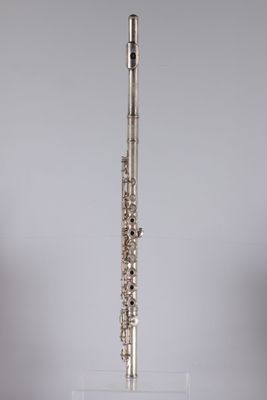 an old silver flute sitting on top of a clear box