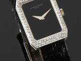 gros plan d'une montre sur une surface noire avec un fond noir