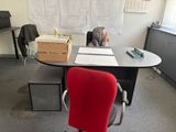 un bureau avec une chaise rouge et un tableau blanc accroché au mur