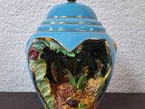 un vase bleu contenant un poisson, posé sur une table