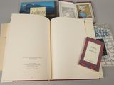a book open on a table with several books on it