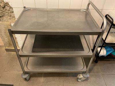 a metal cart with two trays on it in a kitchen