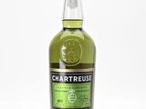 un gros plan d'une bouteille de Chartreuse posée sur une surface blanche
