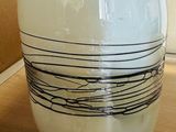 a white vase sitting on a table with a tag on it