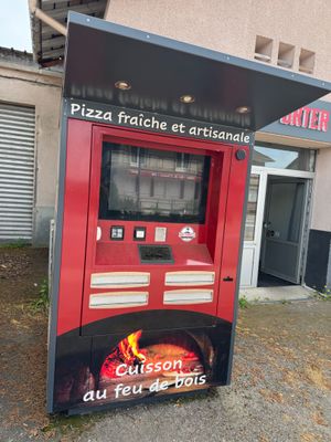 a red vending machine sitting outside of a building