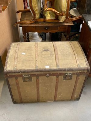 a wooden chest sitting next to a chair and a mirror