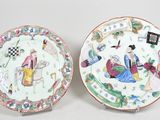 une paire d'assiettes chinoises ornées de personnages, posées sur une table