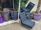 a pile of chairs and a table in the yard