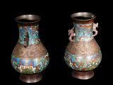 two vases sitting side by side on a black background