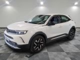 Le SUV blanc est garé dans une pièce au sol carrelé en damier.