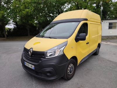 une camionnette jaune garée sur un parking avec des arbres en arrière-plan