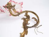 a pink flower that is sitting on a gold plate