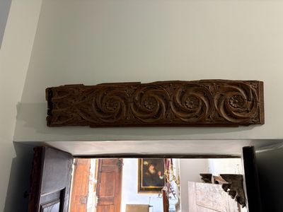 a wooden carving on the wall above a doorway