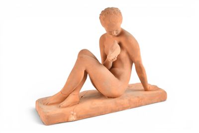 statue d'une femme assise sur un bloc, les jambes croisées