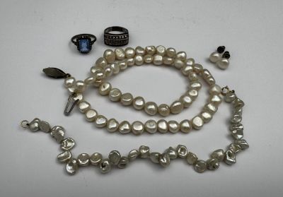 a white pearl necklace and bracelet with a ring on it