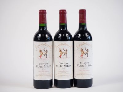 trois bouteilles de vin rouge posées l'une à côté de l'autre sur une surface blanche