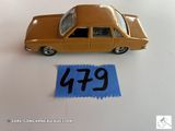 une petite voiture posée à côté d'une feuille de papier bleue
