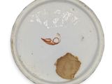 a white plate with a brown piece of food on it