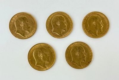four gold sovereigns of different sizes and shapes on a white surface