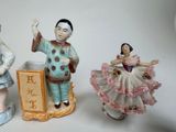 three figurines of a man and a woman on a pedestal