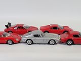 several toy cars are lined up in a row on a white surface