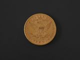 a gold coin on a black surface