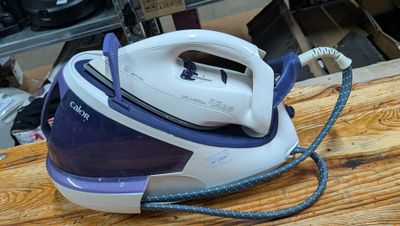 a blue and white steam iron sitting on a wooden table