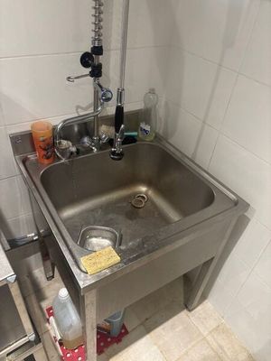 un lavabo dans un coin de la salle de bains, équipé d'un robinet