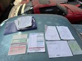 a lot of papers on the hood of a car