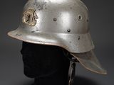 an old helmet on a mannequin head on a gray background