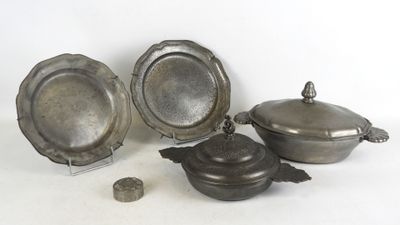 trois assiettes plaquées argent et un bol posés sur un plan de travail blanc