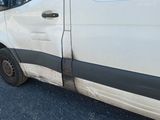 une camionnette blanche avec une bande noire, garée sur le bord de la route