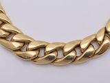 a close up of a gold chain necklace on a white background