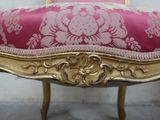 a pink and gold chair with a gold frame on it