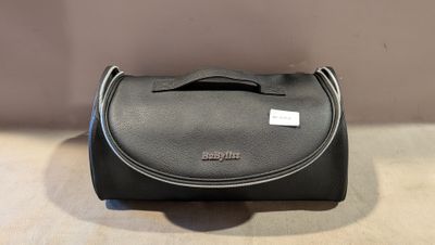 un petit sac noir posé sur une table près du mur