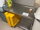 a yellow basket sitting on the floor next to a trash can