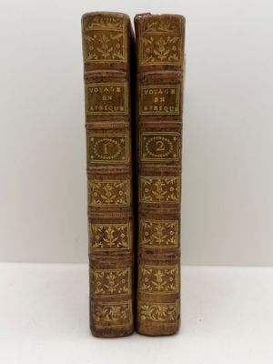 a pair of old books sitting on top of a white table