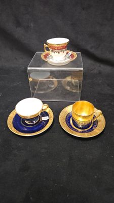deux tasses et soucoupes posées sur une table, à côté d'une boîte transparente