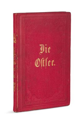 un livre rouge aux lettres dorées posé sur une surface blanche