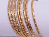 a close up of a stack of gold bracelets on top of a napkin