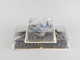 une pile de récipients en plastique remplis de nourriture posée sur une surface blanche