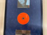 an orange disc in a black frame with a picture of a man