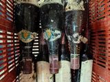 several bottles of wine are in a red basket on a table