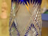 un vase en verre bleu posé sur une table en verre