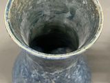 a blue vase that is sitting on a table