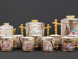 a group of cups and a teapot sitting on a table