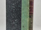 an old book sitting on top of a white table next to a green book
