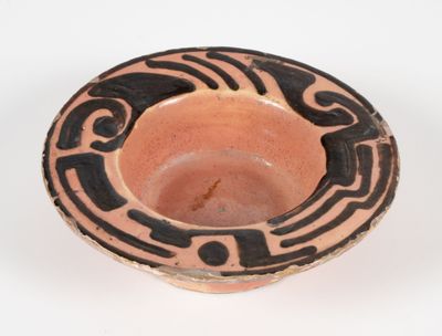 un bol marron orné de motifs noirs sur un fond blanc