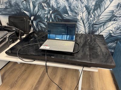 un ordinateur portable posé sur un bureau devant un mur
